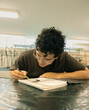 © Fabian Vargas - Young male student drawing in sketchbook during art class