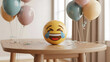 © Mubin - Laughing crying emoji on table with balloons and confetti, wooden table