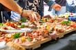 © Thomas - Buffet traiteur avec planches de charcuterie, fromages et tapas lors d’un événement convivial en extérieur.