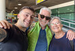© luciano - Young Man Taking Selfie With Smiling Grandparents At Airport Terminal Before Trip