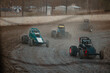 © Austockphoto - Sprint cars race on a dusty dirt track, kicking up clouds of dirt as they compete