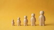 © Yuliia - Five wooden figurines arranged by increasing height on a yellow background, symbolizing human growth, development stages, and life progression.
