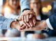 © alphaspirit - Hands come together in a group meeting to show support during a business discussion at a work event in a city