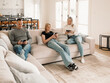 © Austockphoto - Family of three sitting comfortably on the couch while on their phones