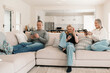 © Austockphoto - Family of three sitting comfortably on the couch while on their phones