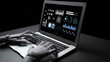 © InfiniteFlow - A futuristic robot hand interacts with a laptop displaying complex data visualizations in a dark setting, symbolizing advanced technology and data analysis. Gantry