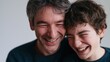 © Chandlerlikes - Father and disabled son laughing together at home, authentic joyful family moment