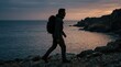 © FACTORY GRAPHICA  - Silhouetted Male Hiker Walking Along Rocky Coastline at Sunset