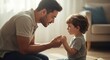 © mudrikah - A caring father kneeling down and holding hands with his young son at home.