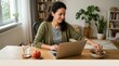 © spyrakot - Remote worker reaching for healthy snack while working at home