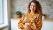 © Pinklife - A radiant pregnant woman smiles gently in a cozy indoor setting, showcasing the beauty of motherhood and the warmth of family, symbolizing love and anticipation in a nurturing environment.