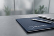 © milkovasa - Blue leather notebook with EU Business logo and pen on office desk