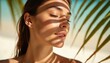 © Viktor - Young woman with closed eyes and smooth skin enjoys sunlight filtering through palm leaves. Tropical shadows create beautiful patterns on her face. She looks relaxed and serene.