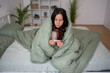 © Jelena - Woman checking temperature in bed feeling sick with fever