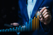 © JK_kyoto - Business growth concept. Businessperson drawing rising bar chart and arrow, profit increase, financial success, revenue strategy, market analytics, investment planning