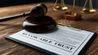 © Muhammad - A gavel and scales of justice on a wooden desk with a revocable trust document