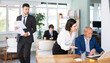 © JackF - Young female business worker helping mature male colleague with laptop, discussing new project in modern office