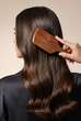 © AsmArif - Woman brushing her long healthy brown hair with a wooden brush hair care daily routine self care hair treatment silky hair smooth hair salon blow dry