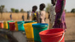 © A2Z AI  - Colorful buckets line up as children wait for water, depicting the vital importance of natural resources in a sun-drenched, rural setting