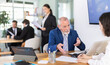 © JackF - Professional senior man bank employee talking and signing loan agreement with young woman client in modern bank office