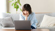 © Trickster* - リビングのソファでノートパソコンを使う女性, Woman Using a Laptop on a Living Room Sofa