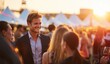 © Selvi - Smiling young businessman in formal attire engaging with diverse people at outdoor social event during sunset
