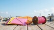 © Masque - Colorful kites and a pink thread spool for the joyful Uttarayan festival under a clear blue sky.