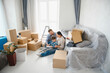 © Serhii - Family moving to new home unpacking living room