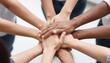 © Tati - Group of diverse hands stacked together symbolizing teamwork, unity, and collaboration