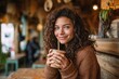 © SUPHANSA - Smiling young woman enjoying a drink in a cozy café surrounded by rustic decor and natural light, embracing a relaxed and joyful atmosphere