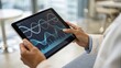© adaptable_ Lark98A1 - A person uses a tablet displaying complex scientific data including DNA helix and wave graphs, suggesting research or analysis in genetics or biotechnology.