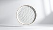 © Nayy - A delicate plate floats in air on white table with sunlight casting shadows