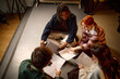 © TrueFrame Collective - High angle view of diverse students reviewing scripts on floor, collaborating in study group or drama class. Education, teamwork, youth learning campaign or school promotion use