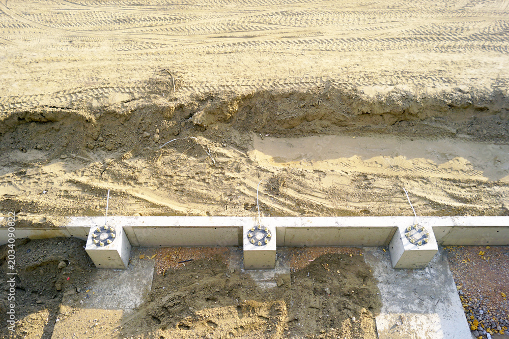 Top-down view of a concrete foundation beam with anchor bolt pedestals ...