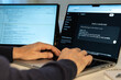 © Fabio Principe - Milan, Italy 3/19/2026 Programmer hands typing on laptop keyboard using ChatGPT artificial intelligence software to find bugs in Python code with dual monitor setup for modern software development