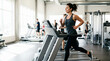 © Xenia - Young woman running on a treadmill in a modern gym. Female athlete doing cardio workout for stamina and weight loss. Fitness and health concept