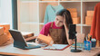 © ArLawKa - Exhausted female online merchant sitting with packages looking thoughtful or sad in her home office warehouse.