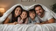 © Raj - Happy family smiling together under white blanket at home showing parents and children bonding cozy lifestyle love childhood comfort togetherness joyful morning and warm family relationship concept