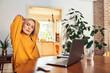 © baranq - Woman stretching neck and back while working at laptop at home