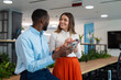© Dexon Dee - Diverse colleagues communicating on smartphones in modern office