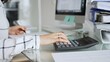 © rogerphoto - Woman calculating finances with black calculator, managing taxes, invoices, and accounting documents in office. Audit and taxes in business