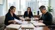 © irawan710 - Three Professionals Collaborating in a Modern Office Meeting Room.