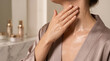 © Skin-Care - Woman applying skincare product on her neck and dcolletage in a luxury bathroom setting