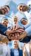 © pattozher - Teamwork Huddle: A diverse group of business professionals in smart attire gathers for a motivational huddle.