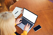 © baranq - Woman typing on laptop with blank screen at home wooden table