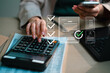 © MarkFinal - Businessman holding magnifying glass focusing on green energy icons and wind turbine model for ESG investment concept