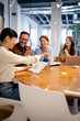 © littlewolf1989 - Business team applauding successful presentation in modern office meeting discussing achievement