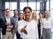 © Athena Studio - Professional young African American businesswoman extending a handshake to welcome new business partners.