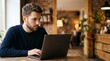© Eve - Focused young Caucasian man with beard working on laptop in cozy cafe remote work and freelance concept commercial professional marketing background