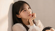 © kazu - ソファでくつろぐ若い女性のライフスタイルポートレート 華やかな印象